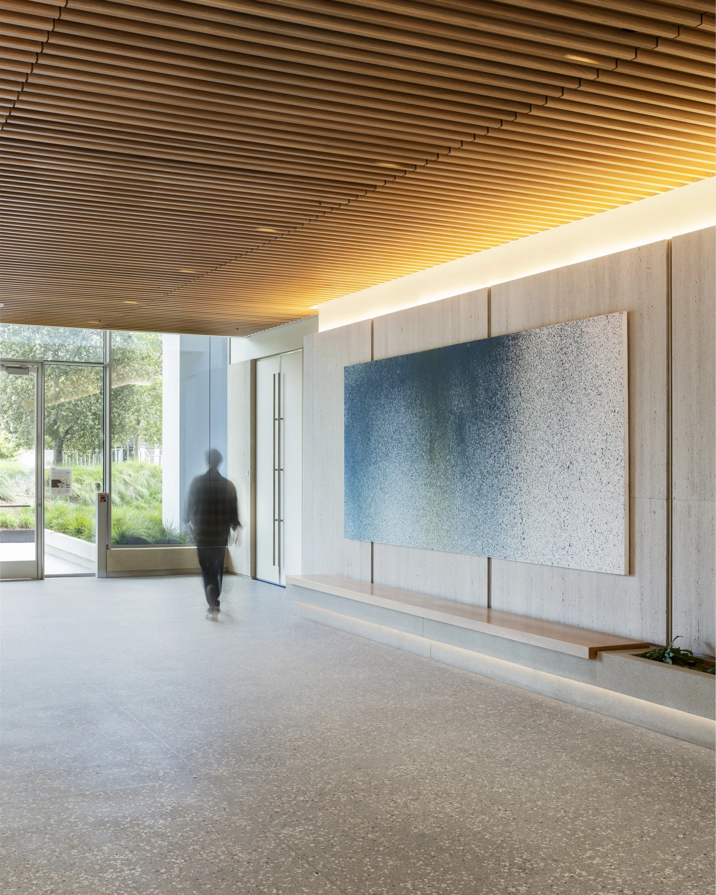 Large blue contemporary painting installed in a modern lobby with a wood slat ceiling