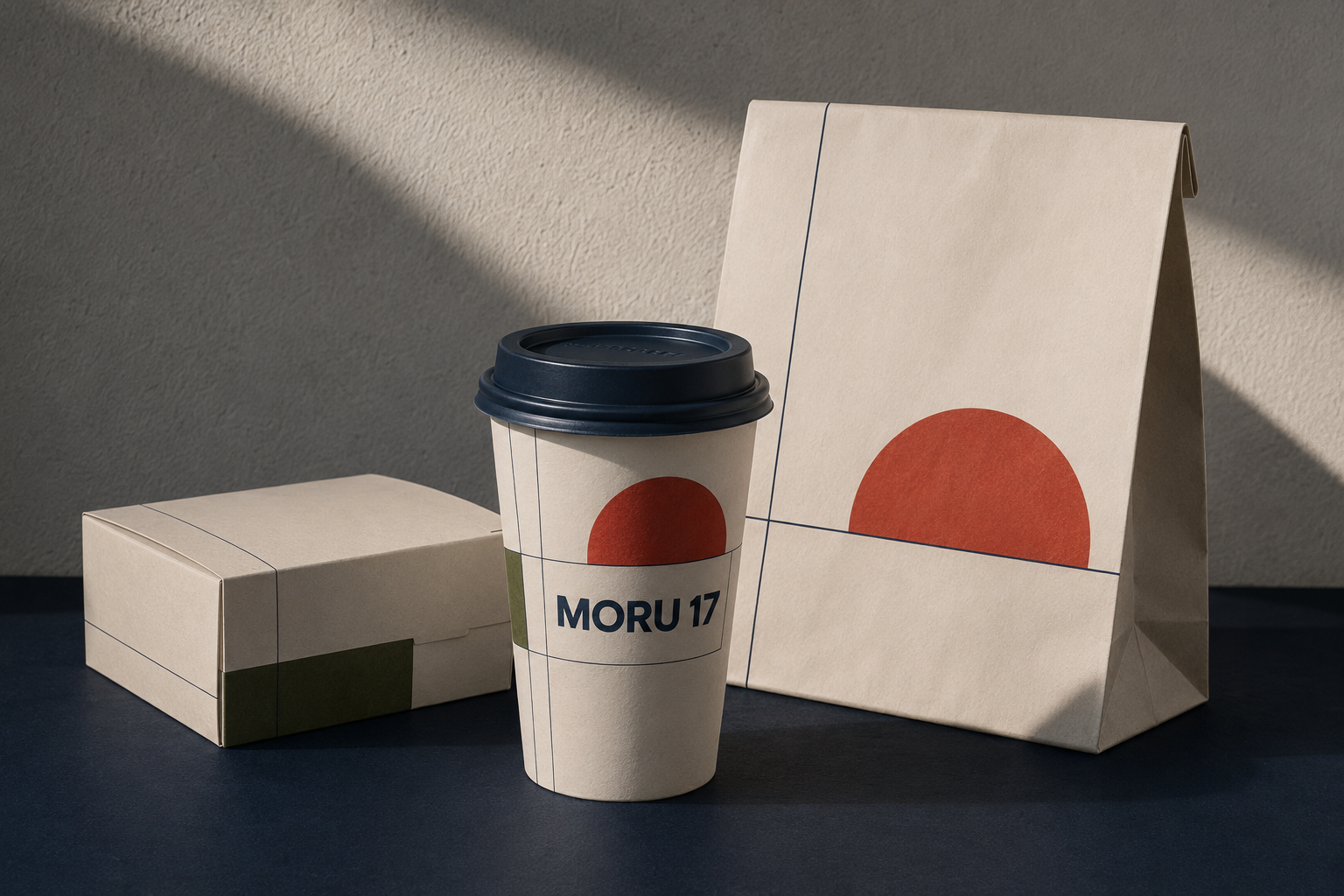 Minimalist coffee cup, box, and paper bag with red circle and MORU 17 branding on beige background.