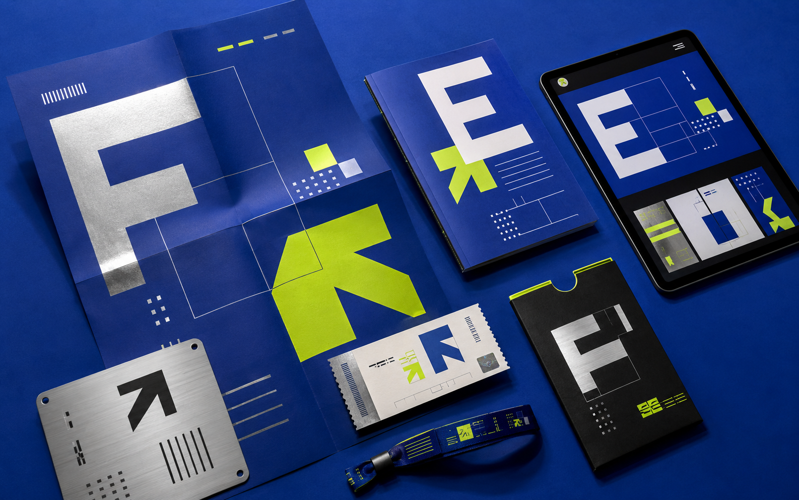 Electric-blue brand kit with geometric identity graphics across cards, booklet, lanyard and digital interface.