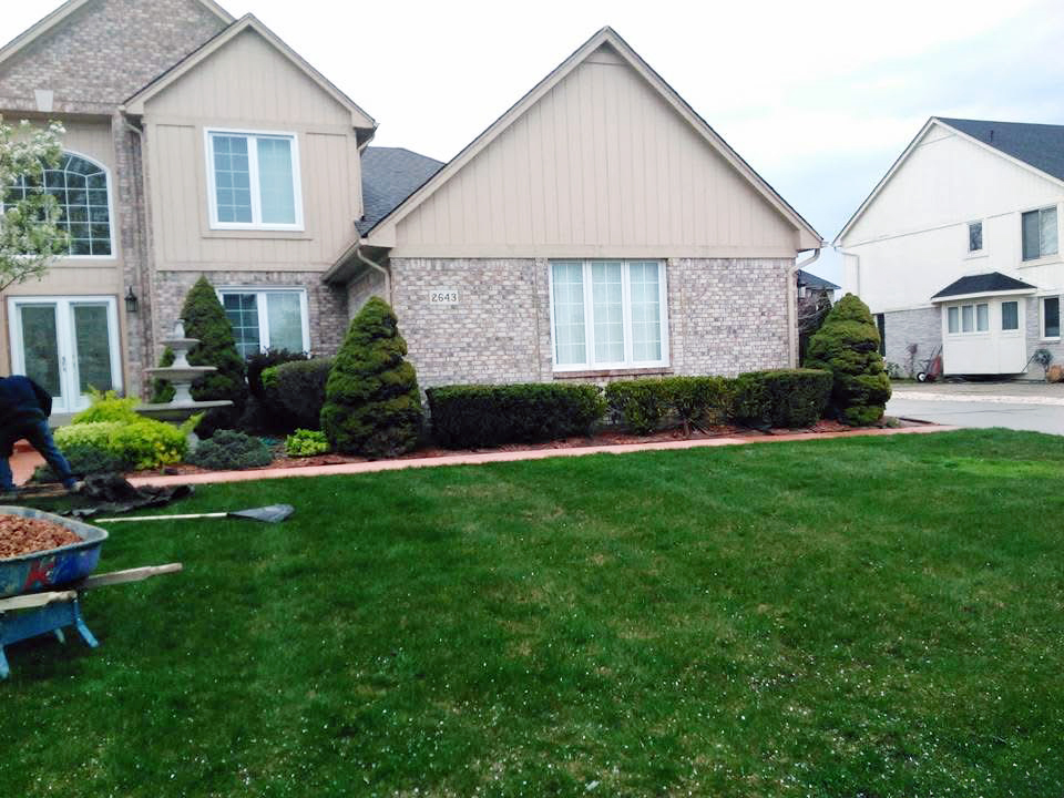 Heritage landscape Professional hardscape and landscape integration, showcasing custom brick paving alongside maintained shrubbery and lawn borders.