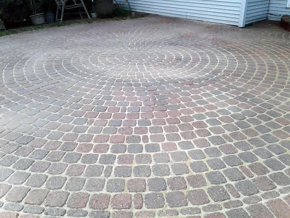 Heritage Landscape Professional masonry installation showcasing a custom circular brick paver patio design.