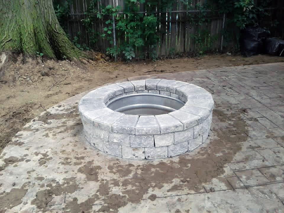 heritage landscape Custom hardscape design and installation featuring a brick paver patio, fire pit, and professional masonry work.
