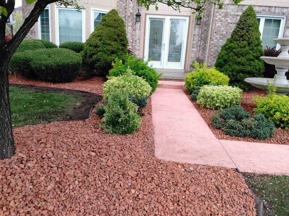 heritage landscape Professional landscaping service showcasing comprehensive shrub trimming, garden bed maintenance, and site cleanup alongside a walkway.