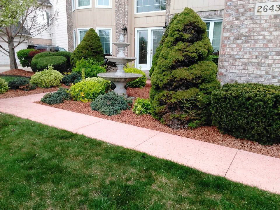heritage landscape Professional landscaping service showcasing comprehensive shrub trimming, garden bed maintenance, and site cleanup alongside a walkway.
