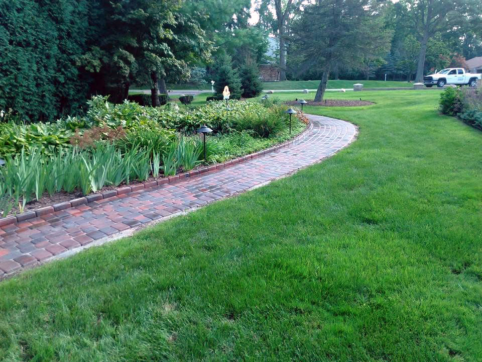 heritage landscape Custom brick paver walkway installation featuring curved masonry and integrated landscape border detailing.
