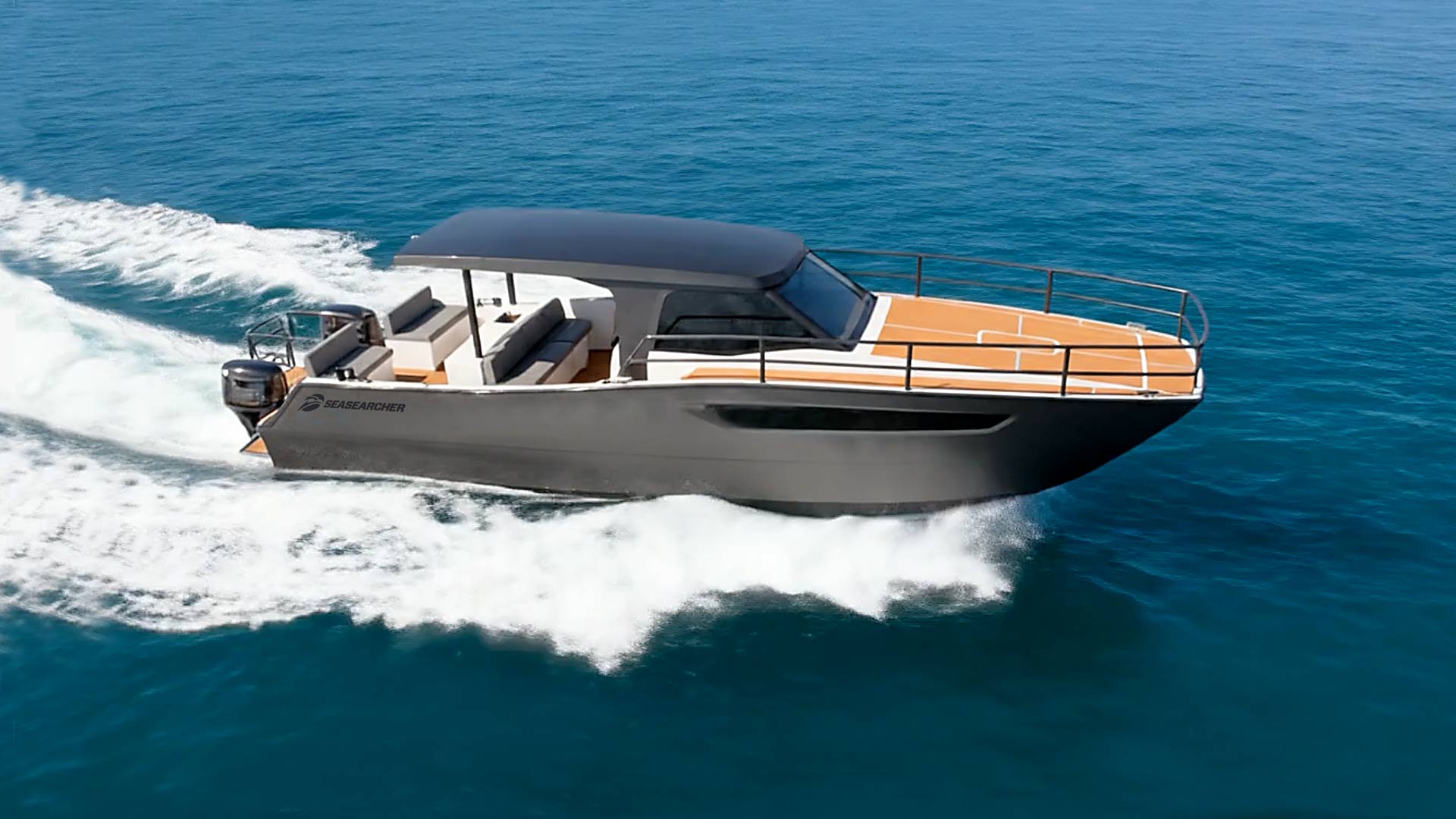 Modern black and tan motorboat cruising fast on clear blue ocean water.