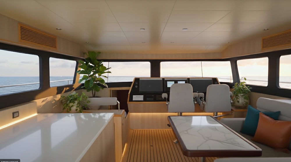 Interior of a boat cabin featuring a steering console with two chairs, a marble-top table, cushioned bench seating with pillows, and large windows showing a sea view.