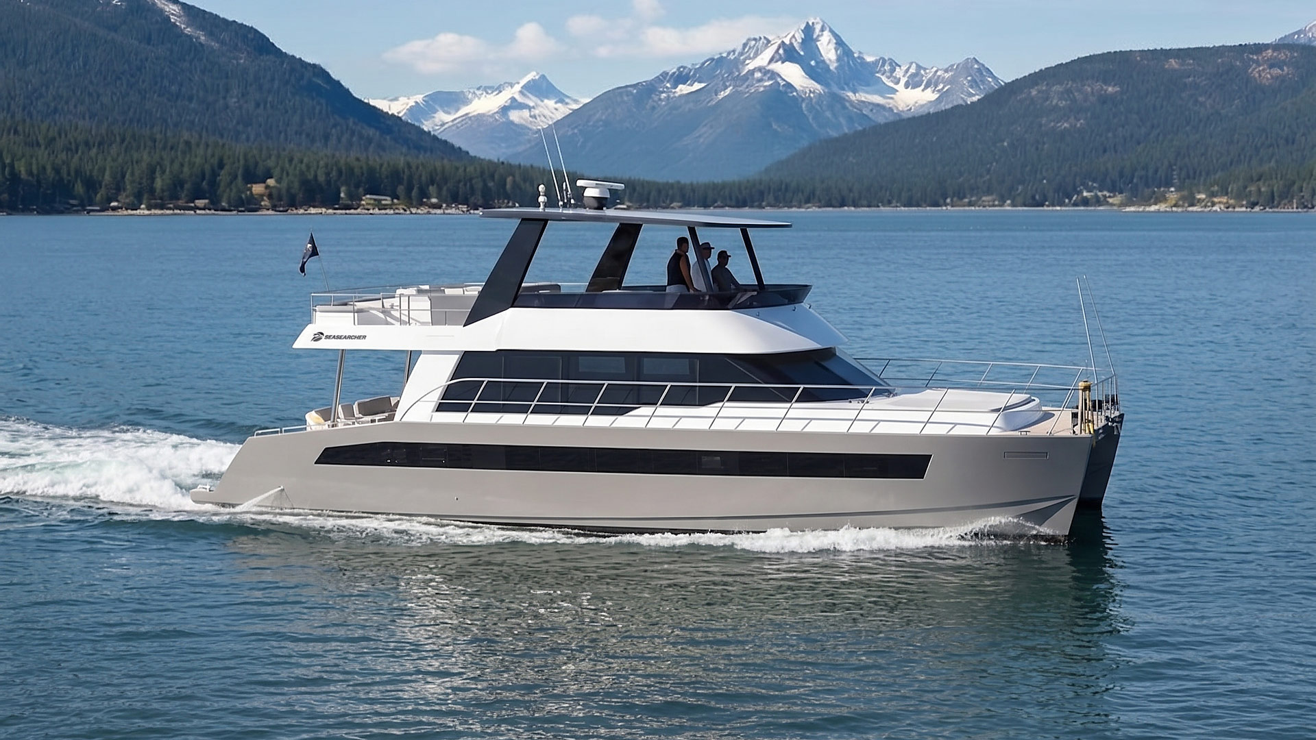 Modern motor yacht cruising on calm blue lake with snowy mountains and forested hills in the background.