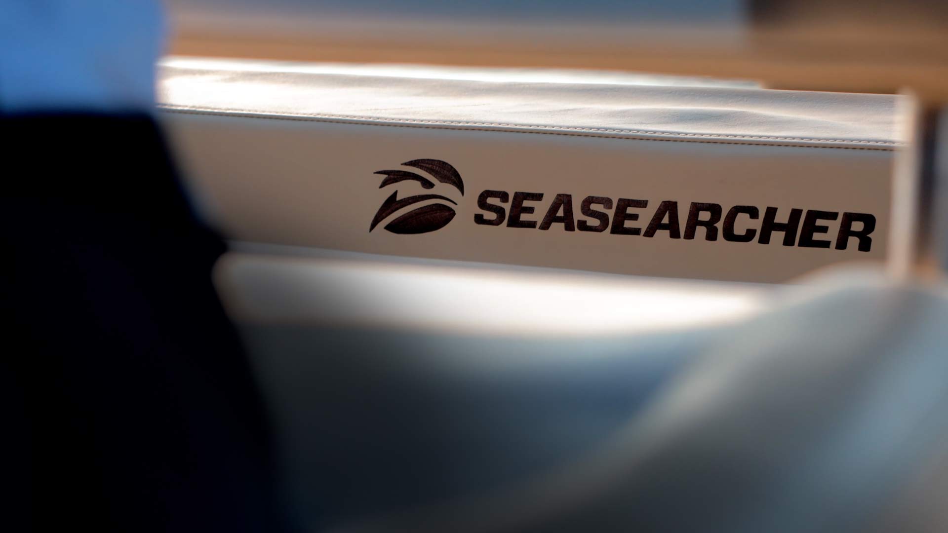 Close-up of the SEASEARCHER logo on a white cushioned surface, likely part of a boat seat.