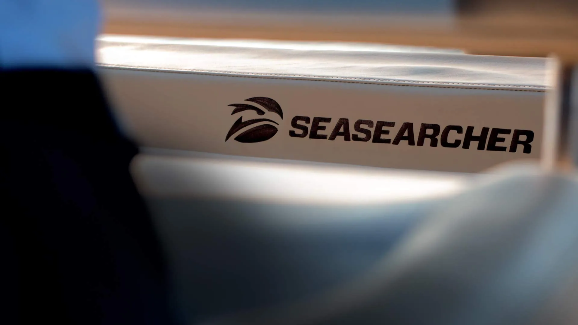 Close-up of the SEASEARCHER logo on a white cushioned surface, likely part of a boat seat.