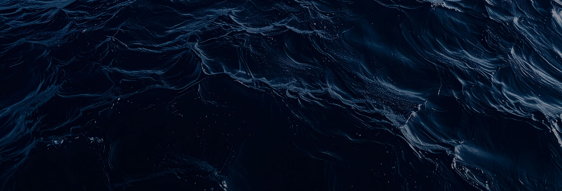 Close-up view of dark ocean waves with textured ripples and light reflections.