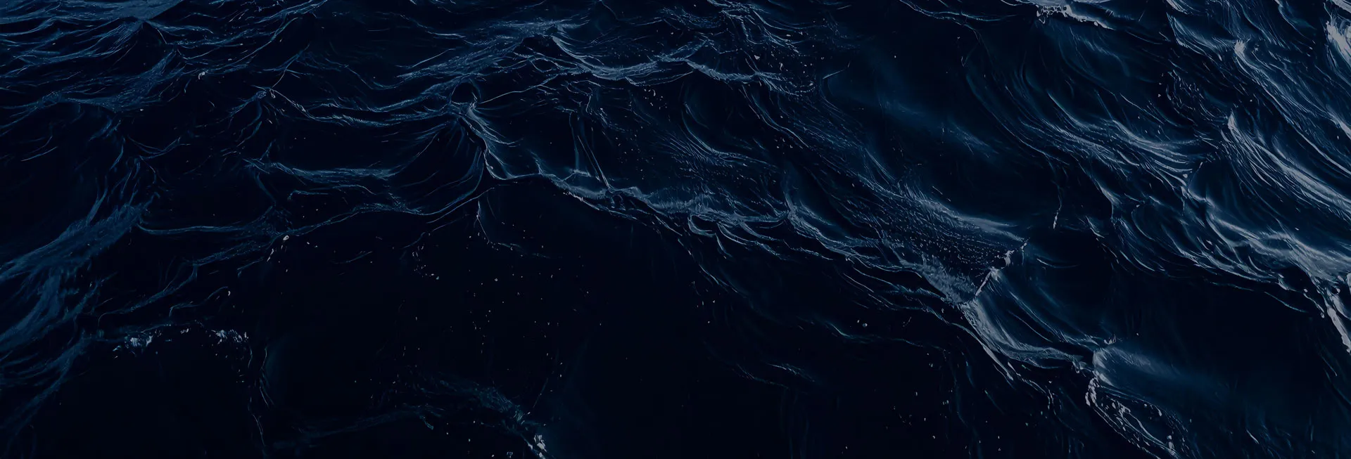 Close-up view of dark ocean waves with textured ripples and light reflections.