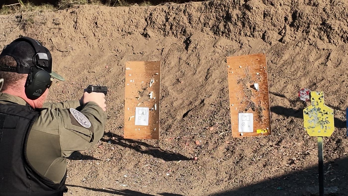 Over-the-shoulder view of a Prime officer engaging paper and steel targets on the range