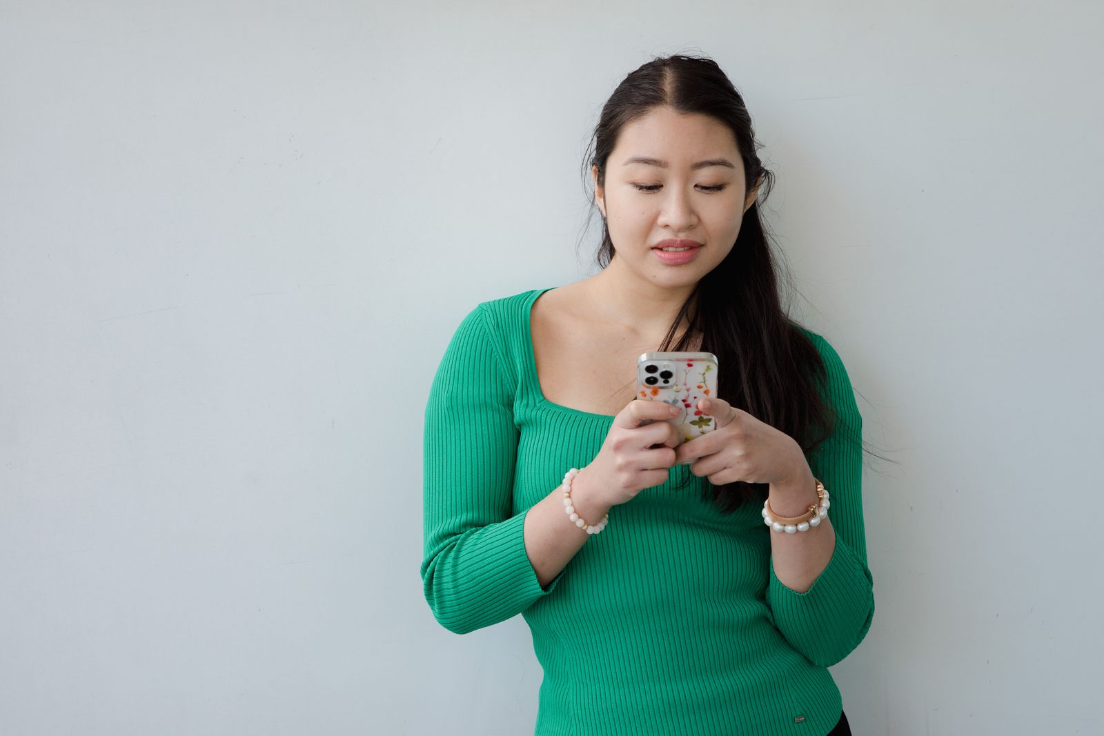 Young Cambodian woman typing a message on her smartphone