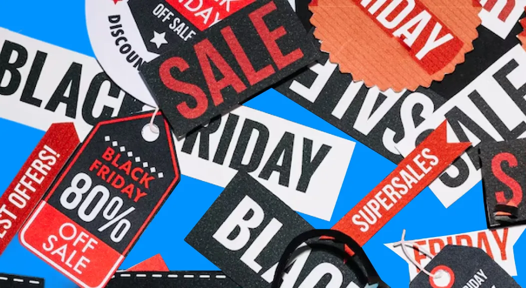 Pile of Black Friday sale tags and discount signs in red, black and white.
