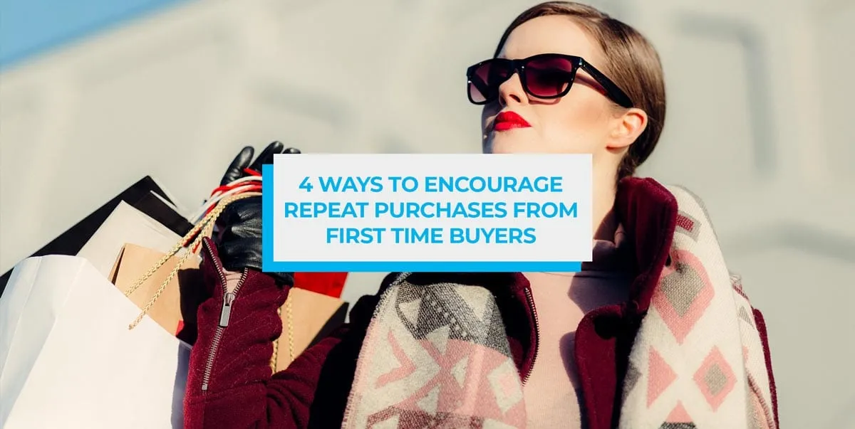 Woman in sunglasses and a patterned coat carrying shopping bags.
