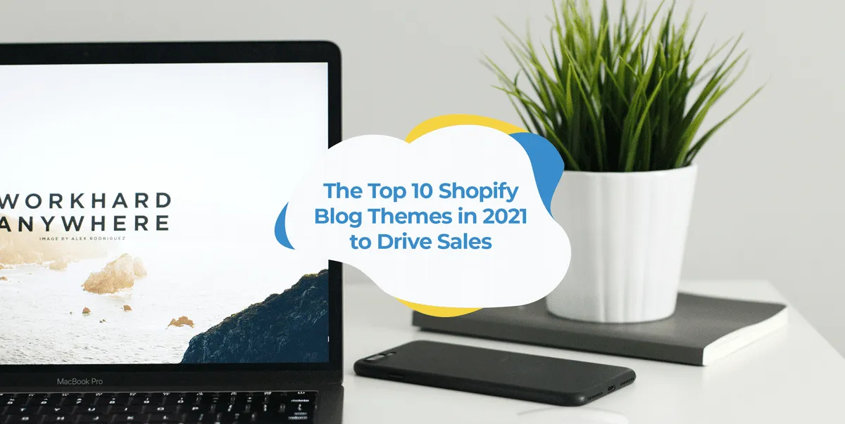 Laptop on a white desk beside a potted plant and a phone.