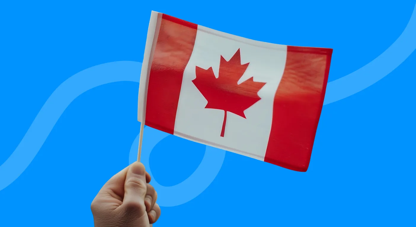 Hand waving a small Canadian maple leaf flag.