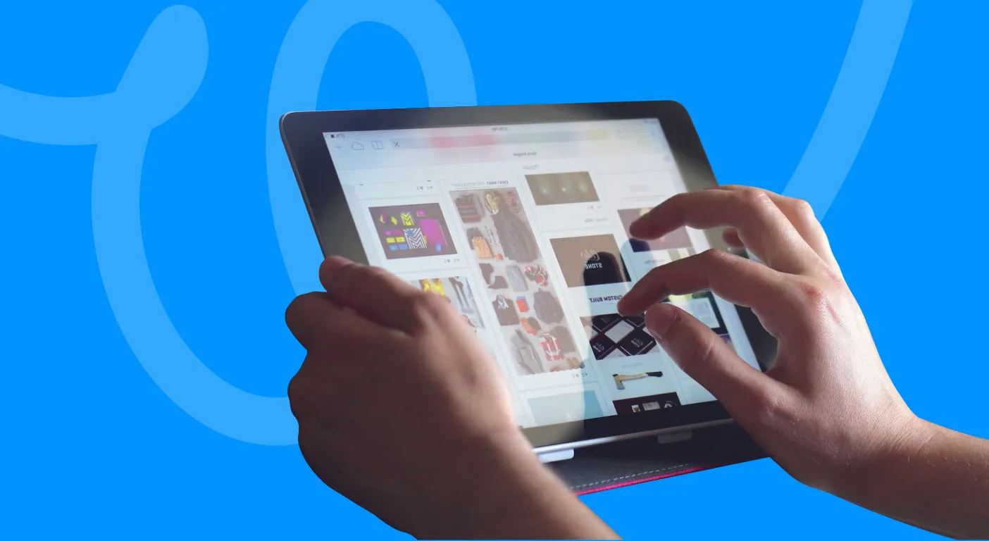 Hands browsing a grid of product photos on a tablet screen.