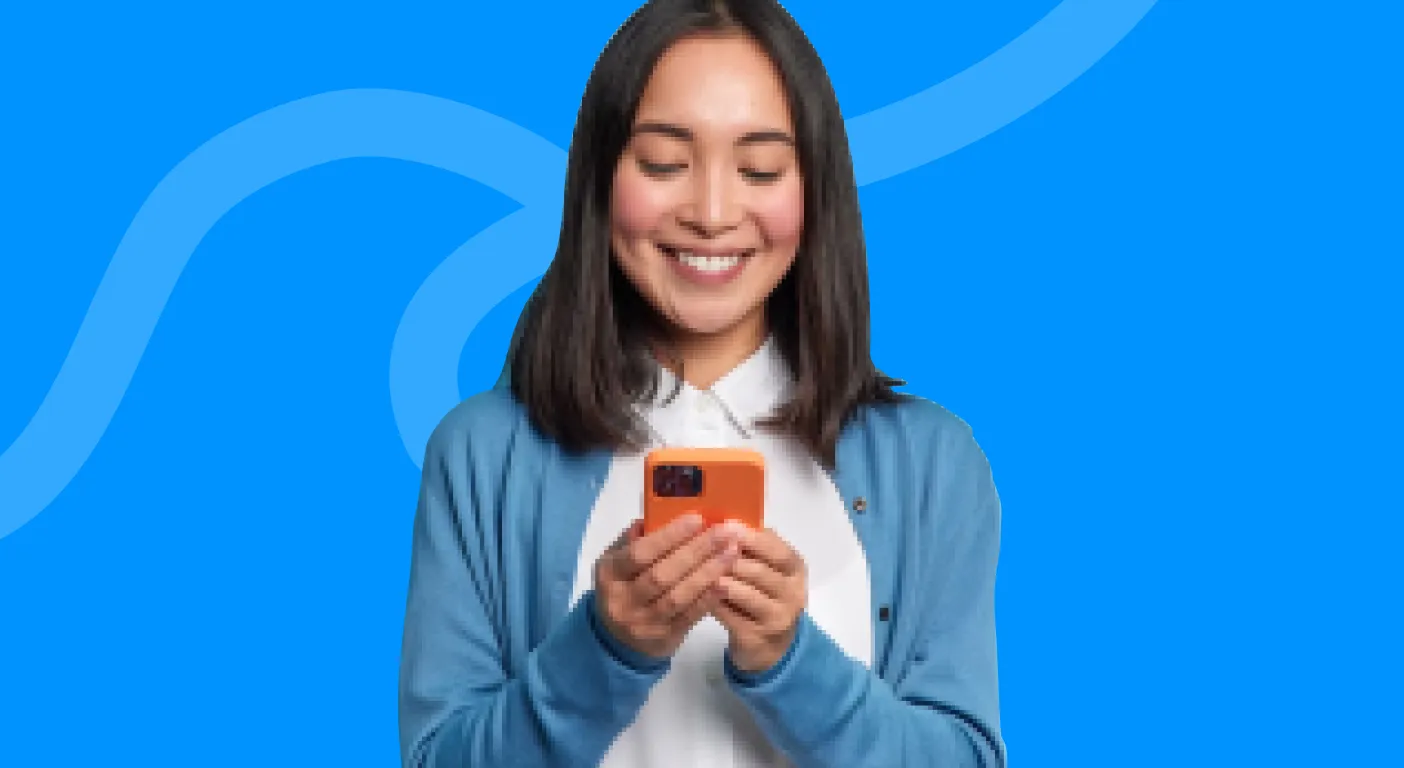 Smiling woman scrolling on her phone against a blue background.