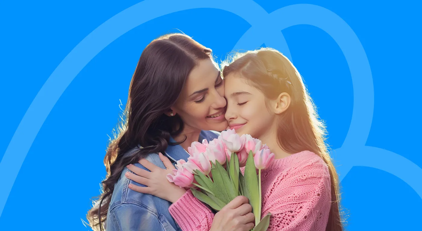 Mother and daughter hugging while holding a bunch of pink tulips.