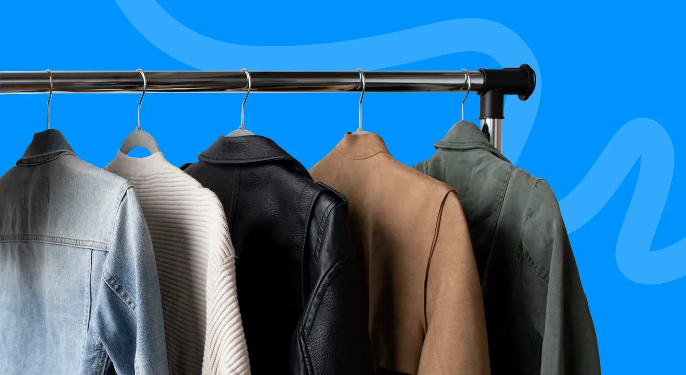 Row of denim, leather and wool jackets hanging on a clothing rail.