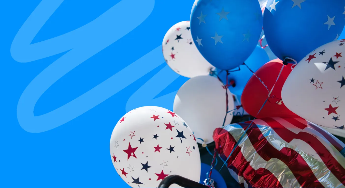 Cluster of red, white and blue star-patterned balloons beside an American flag.