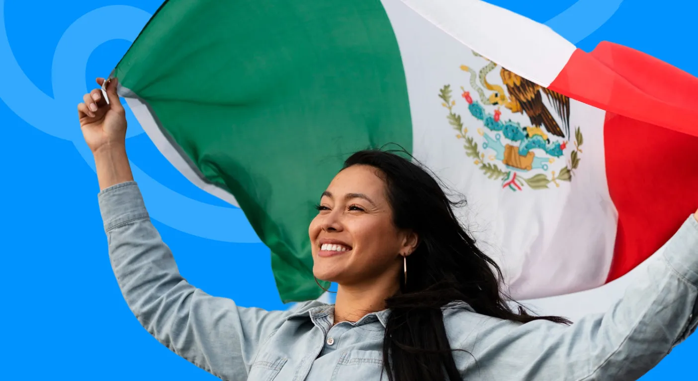 Smiling woman holding a Mexican flag above her head.