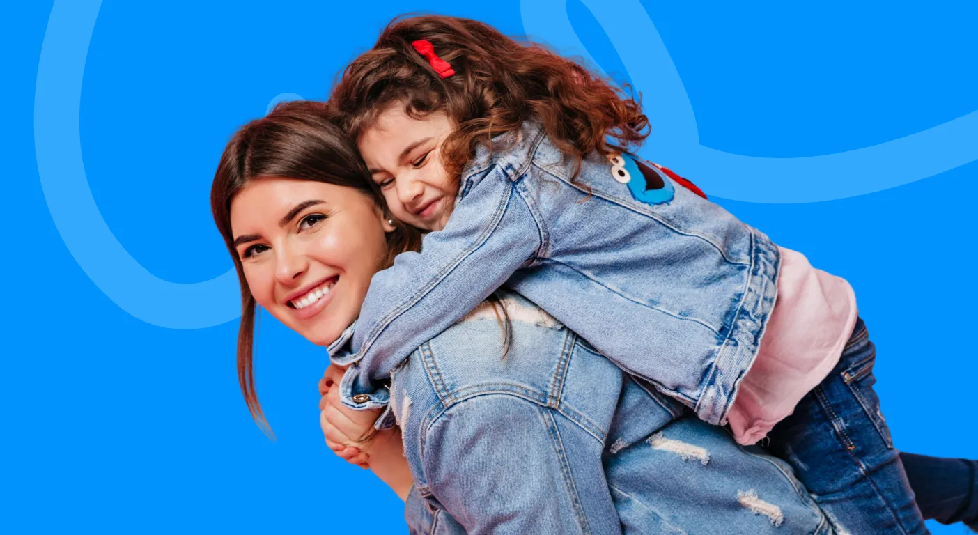 Smiling mother giving her daughter a piggyback ride.