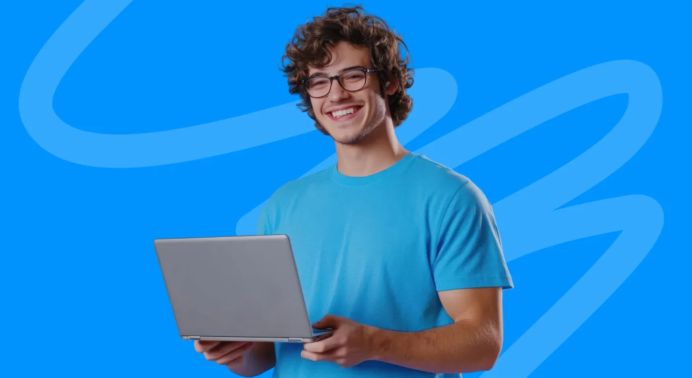 Smiling young man in glasses holding an open laptop.