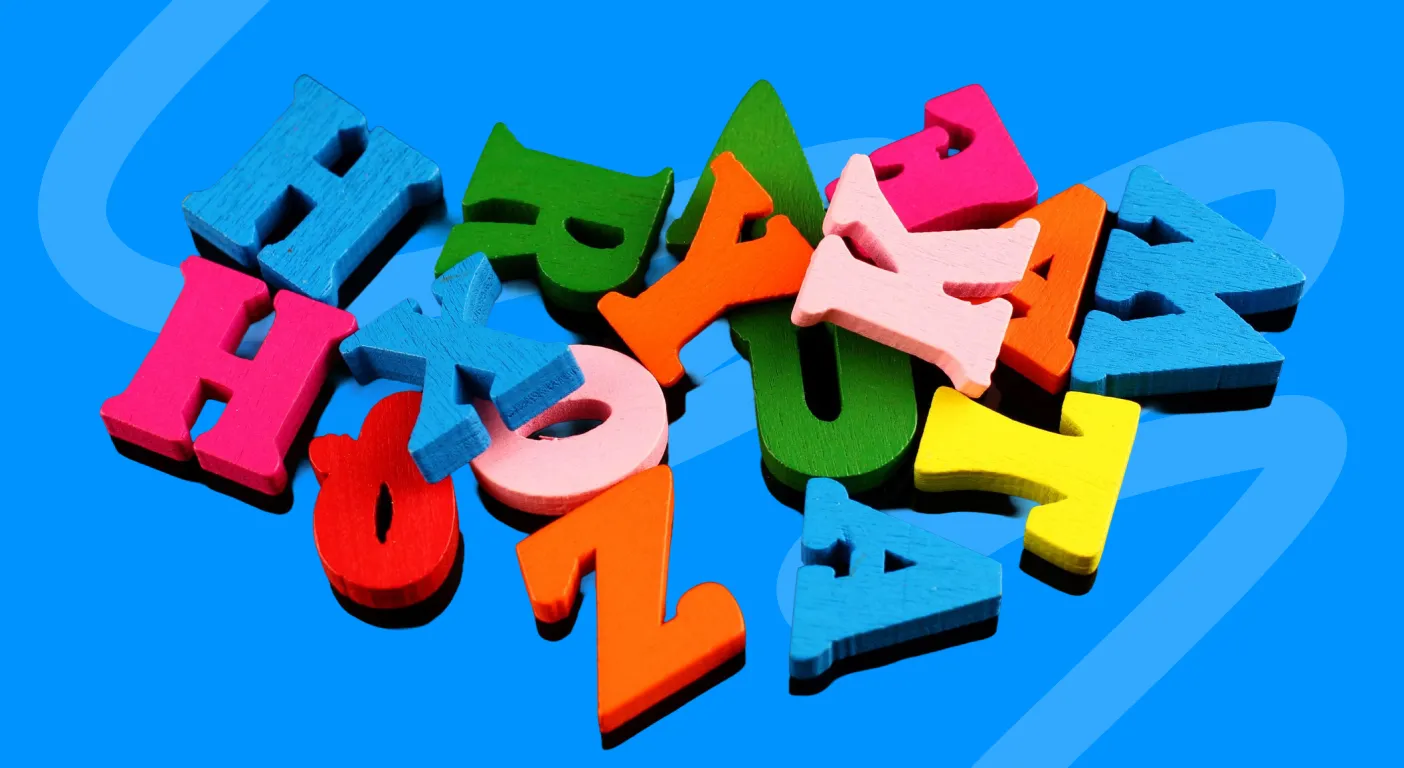 Jumble of brightly coloured wooden letter blocks.