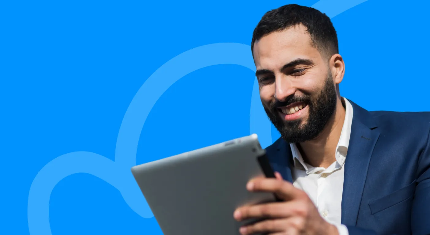Smiling man in a blazer using a tablet to review his BigCommerce store's marketing performance.