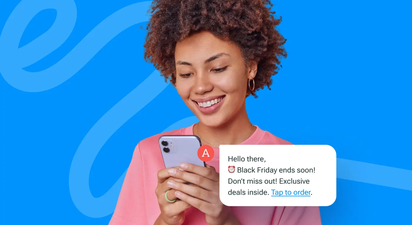 Smiling woman looking at a Black Friday SMS promotion on her phone, with the text message shown beside her.