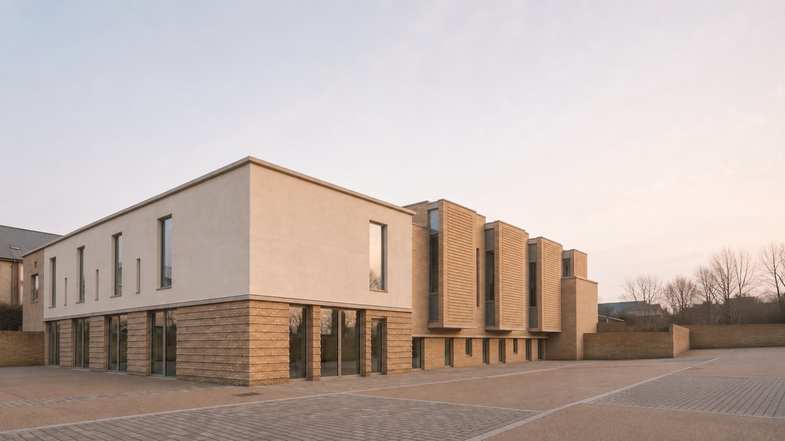Rickett Architects visualisation of the proposed auditorium at the Oxford Business College campus, Carlton Road, Nottingham, in low evening light: a contemporary two storey education building in buff brick with a rendered upper volume, projecting brick screen bays along the flank, a glazed ground floor and a paved forecourt