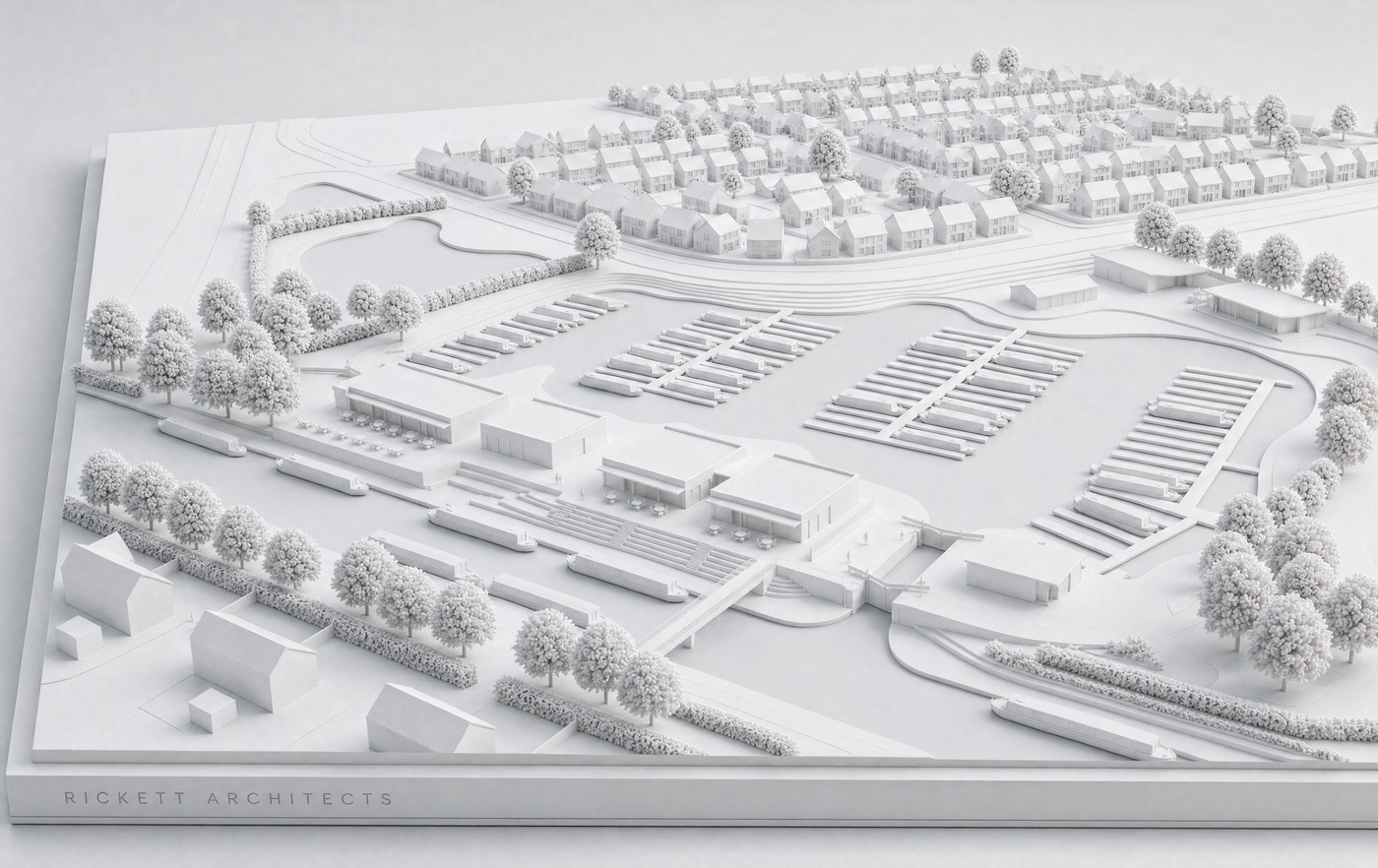 White card study model of the Woods Farm canal-side marina on a plinth: rows of moorings and narrowboats along the basin, low waterfront buildings and a landscaped quay, the canal and its towpath tree belt in the foreground, and the housing stepping away beyond