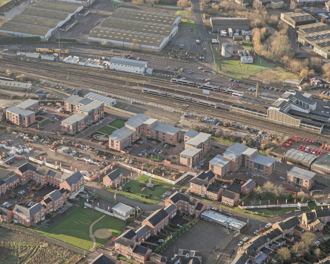 Aerial photograph of the completed Market Quarter in Banbury: brick apartment blocks on the former cattle market beside the railway.
