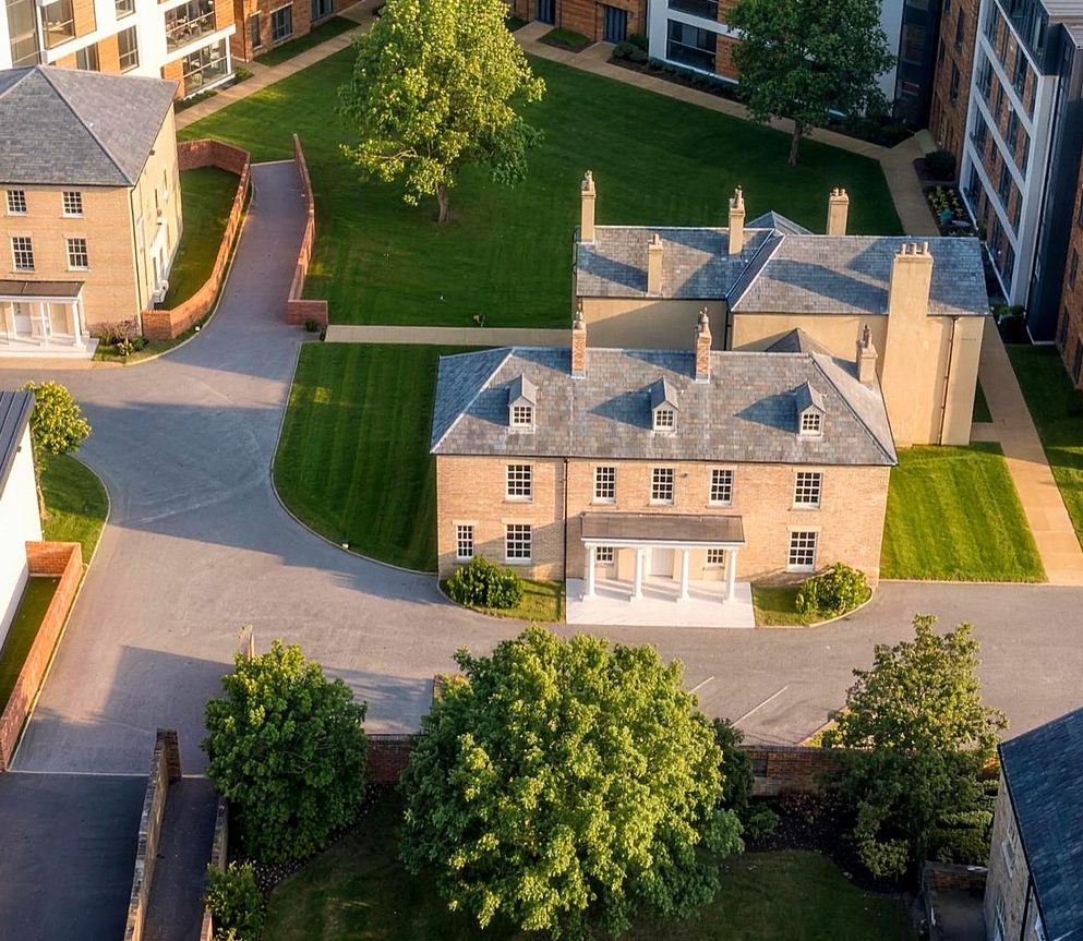 Aerial visualisation of the retained Georgian listed building at Caldecott Square standing alone in a lawned courtyard, with new extra care blocks and mews arranged around the edges of the site and planted boundaries between them