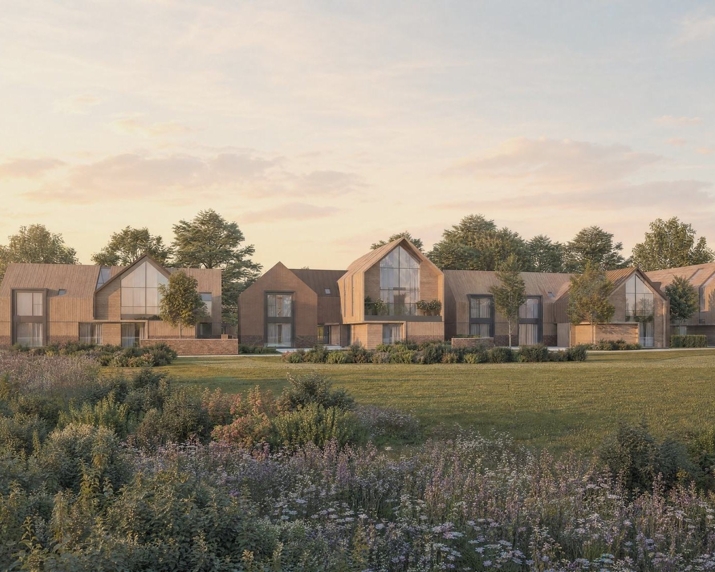 Visualisation of the consented scheme at Inwoods Park, Rugby: a row of timber-clad gabled houses with full-height glazing, seen across the meadow in evening light.