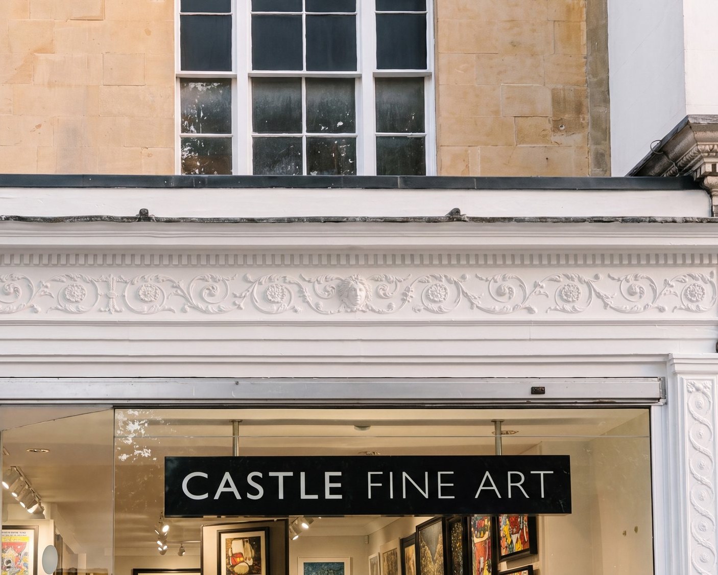 Photograph of the shopfront at 82A The Promenade, Cheltenham, beneath the rare Regency frieze on the listed frontage.