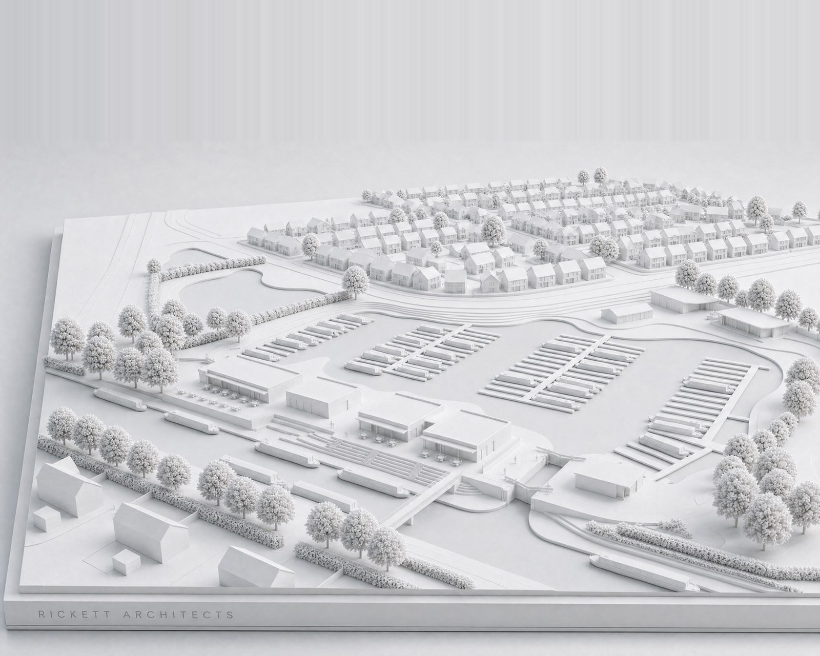 Study model of the canal-side marina in the Woods Farm masterplan at Shirley: a white card model of moorings and a waterfront building, with the new neighbourhood stepping away behind. A study model, not a photograph.