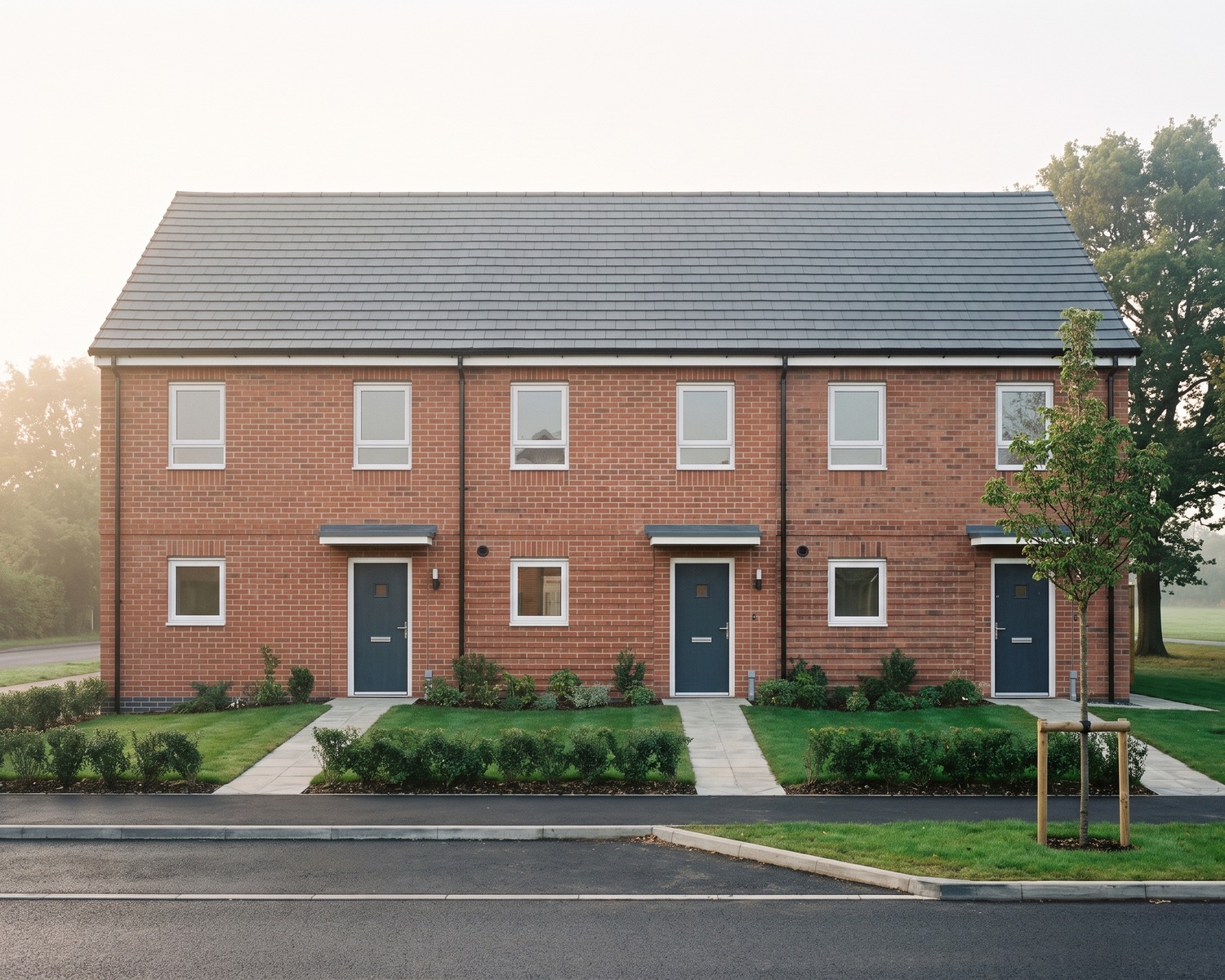 Visualisation of the consented scheme at Redditch Road, Hopwood: a terrace of homes for social rent in red brick, by Rickett Architects