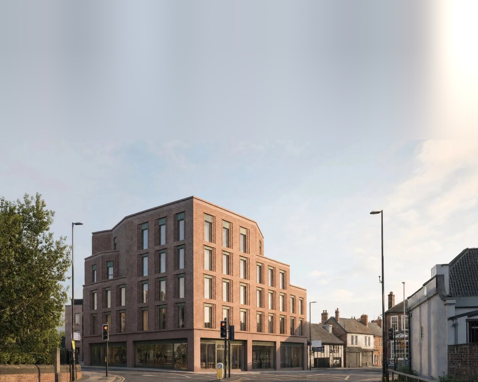 Visualisation of the massing tested on the canal-side plot in Greater Manchester: a brick mixed-use corner building at a town junction, stepping down to the streets either side. A visualisation of a scheme that was tested only, never applied for and never built.