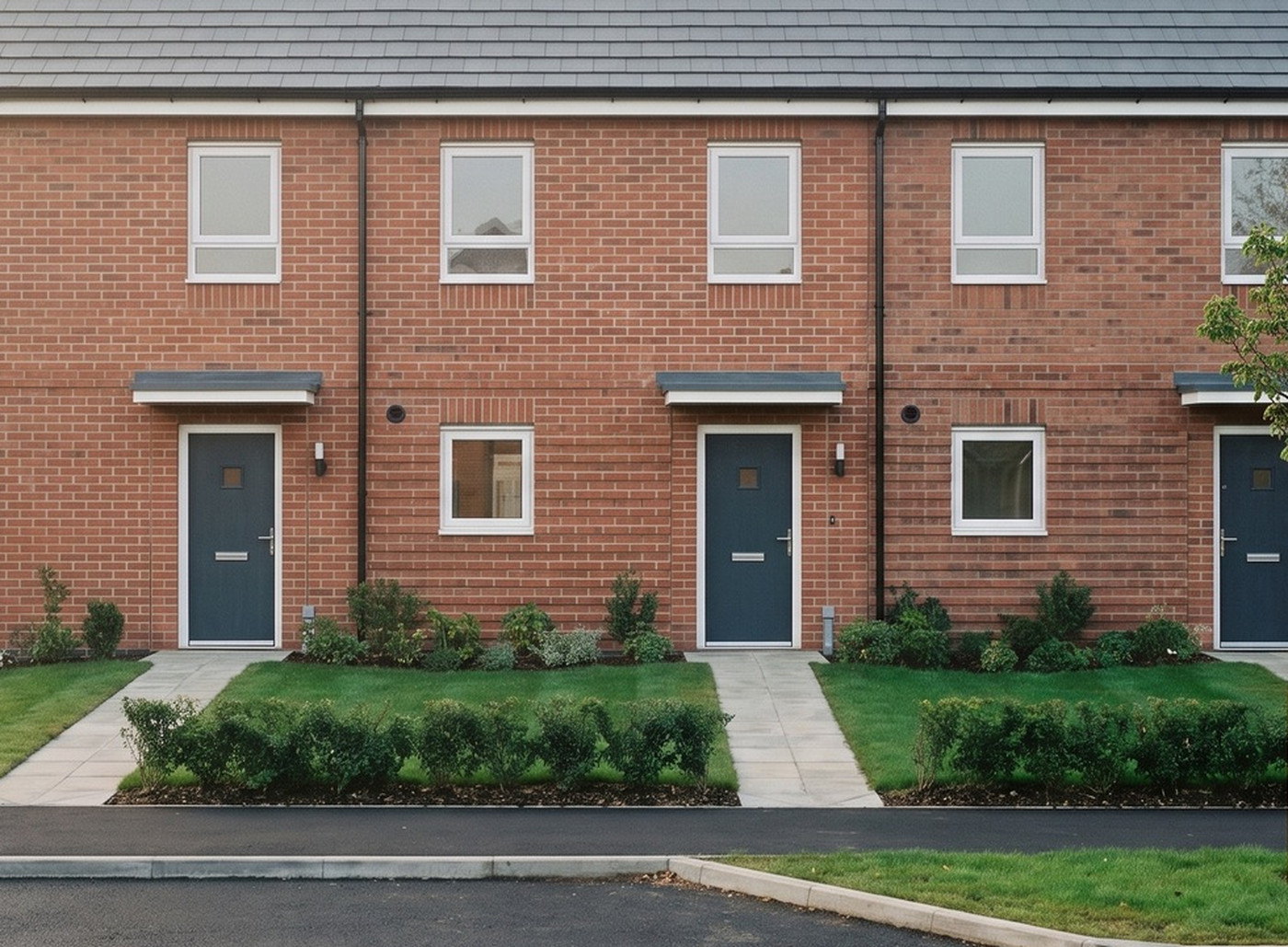 Visualisation of two of the consented homes at Redditch Road, Hopwood: red multi brick elevations with contrasting brick banding, brick soldier lintels above white windows, dark blue front doors under slim canopies, paved paths, clipped hedges and lawn to the frontage