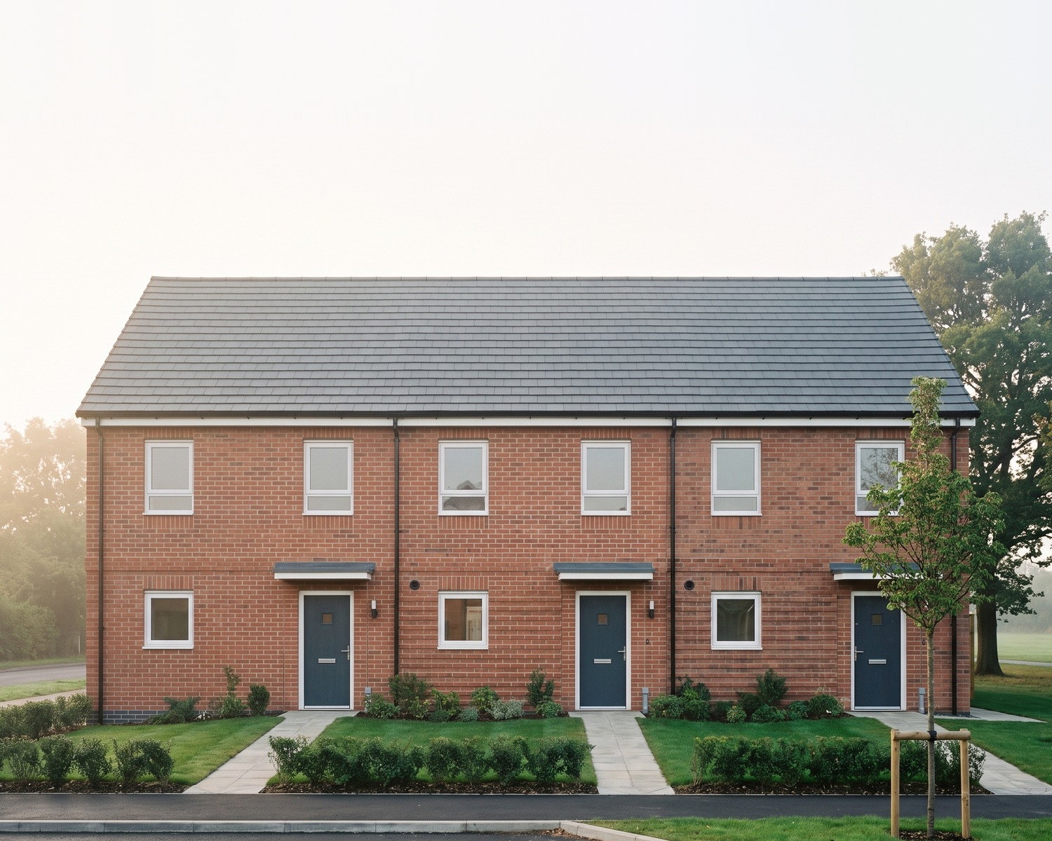 Visualisation of the consented scheme at Redditch Road, Hopwood: a terrace of homes for social rent in red brick, by Rickett Architects.