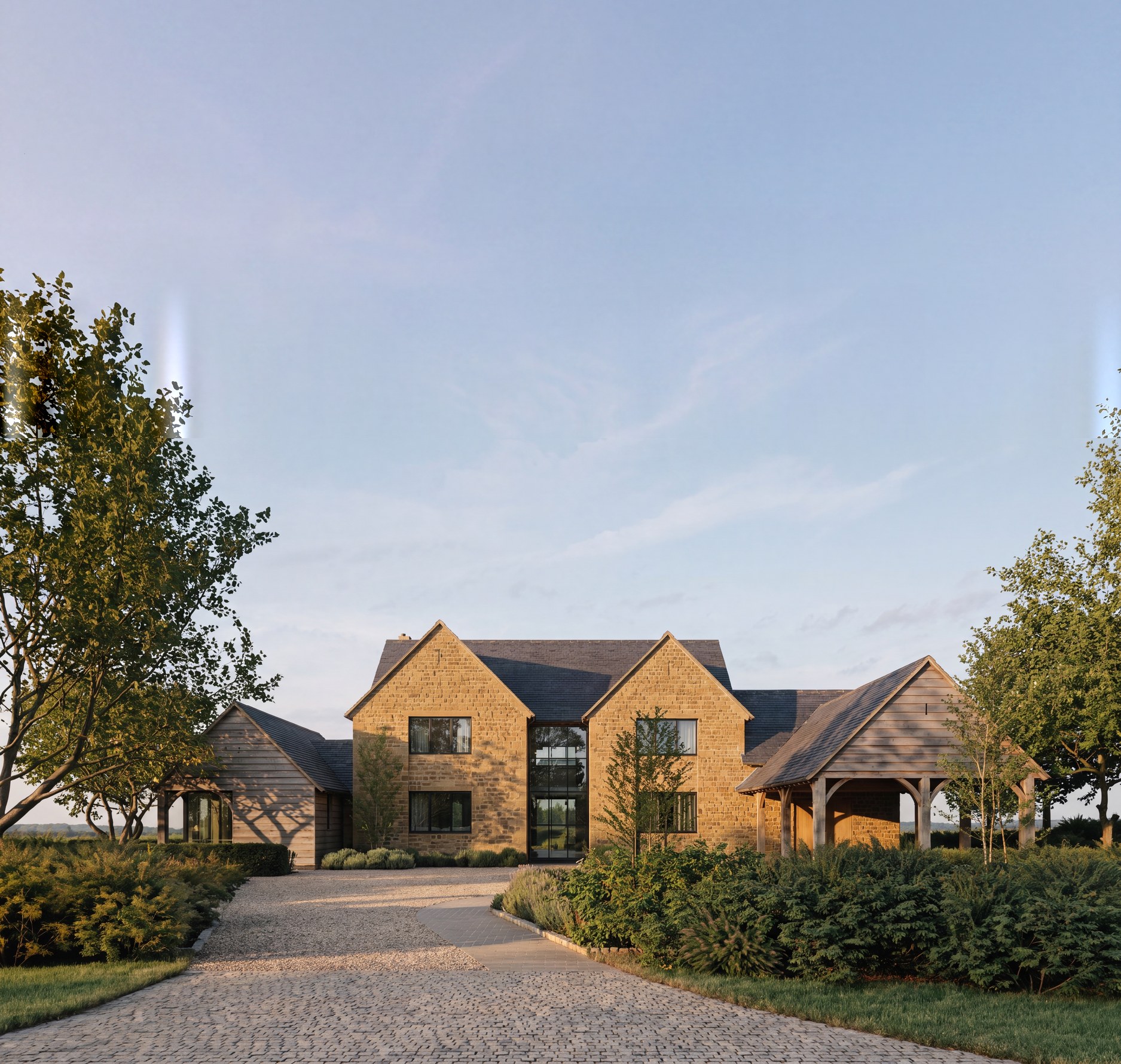 Visualisation of the consented design at Hollow Meadow Farmhouse, Priors Hardwick: a coursed natural ironstone house with paired gables, a recessed full-height glazed centre and an open oak car port.