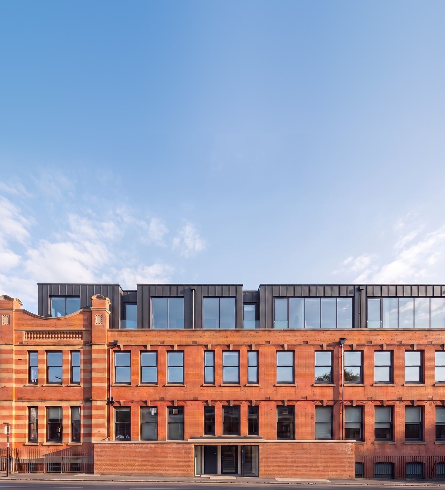 Visualisation of the 1906 works at Foleshill Road, Coventry, being converted to apartments: the retained red-brick and terracotta facade below the new dark zinc-clad top storey.