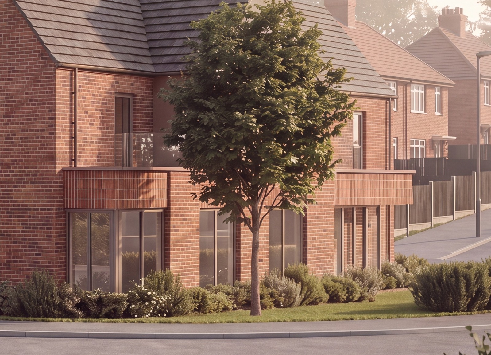 Close view of the proposed corner at Bennetts Road, Keresley: a red brick elevation with tall shopfront glazing at ground floor beneath a projecting brick soldier-course band, glass-balustrade balconies to the first-floor flats above, low planting along the pavement and a young street tree in front