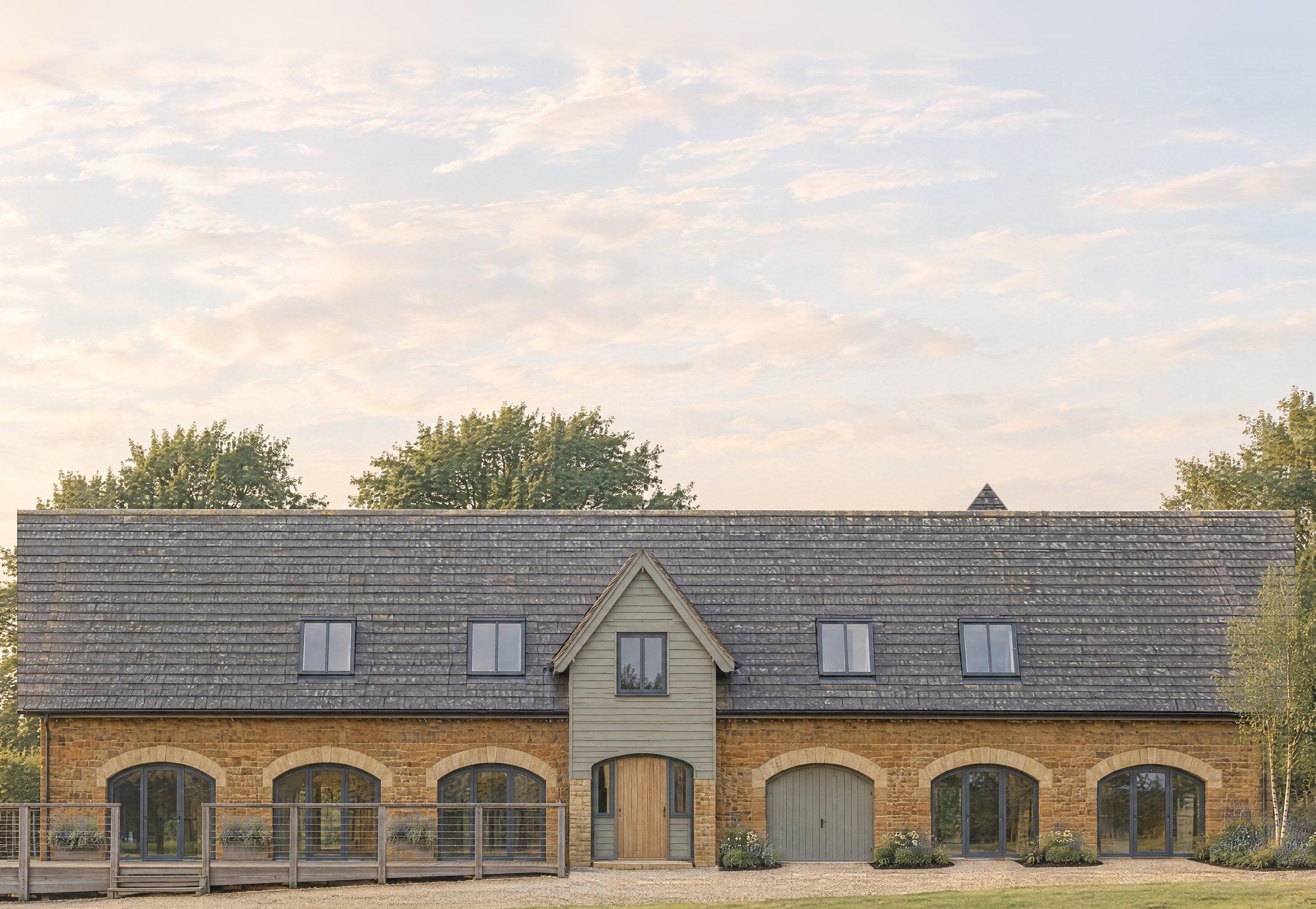 Visualisation of the approved conversion: a long two-storey stone building with six arched openings