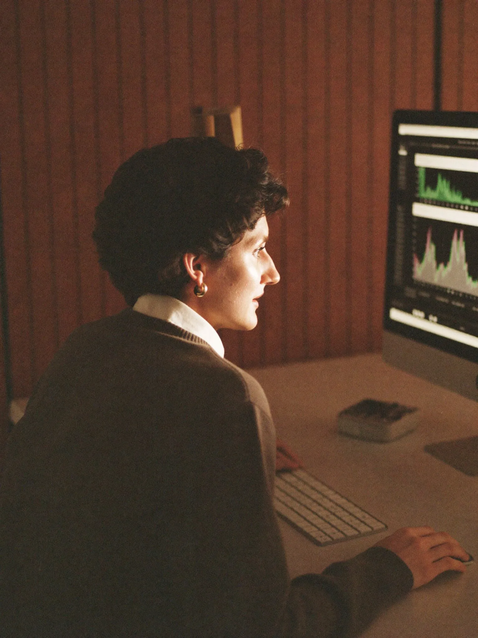 Financial analyst reviewing charts at a computer