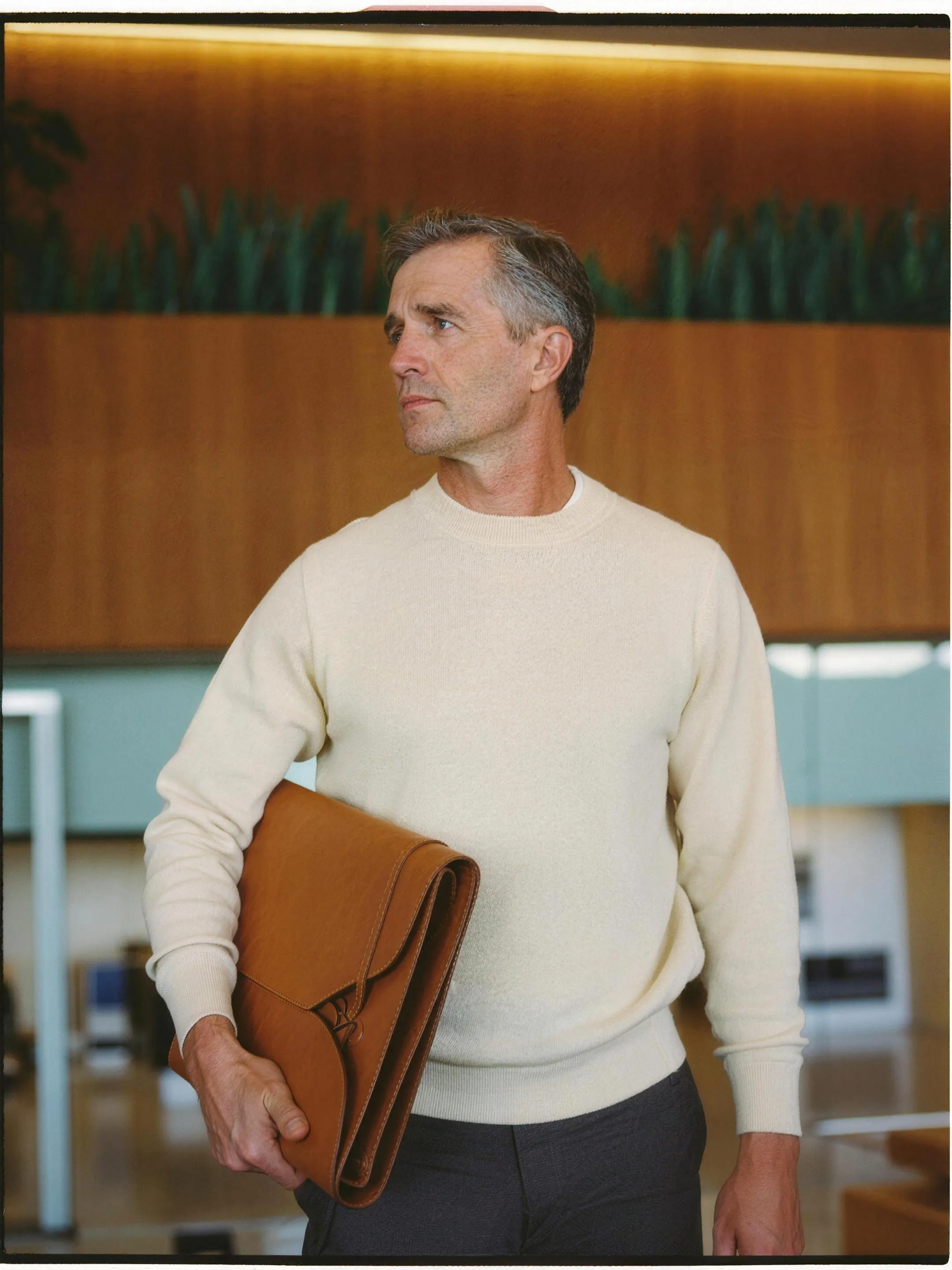 Facilities manager walking a corridor with a folder under his arm